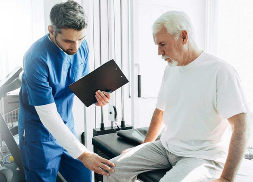 Healthcare-practitioner-examining-elderly-patient’s-knee-for-signs-of-arthritis