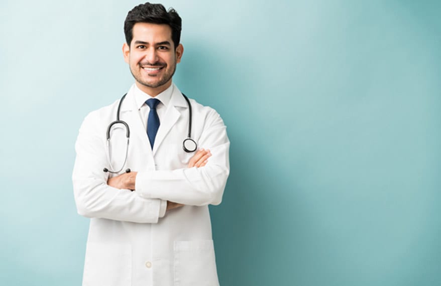 Smiling-male-doctor-in-a-white-lab-coat-standing-with-his-arms-crossed