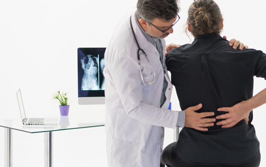 Spine-surgeon-evaluating-a-patient’s-lower-back